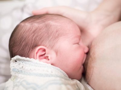 Young,Mother,Breastfeeding,With,Nipple,Shield.,She,Holds,Her,Newborn